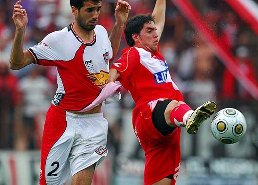 Gabriel Hauche lucha por el balón ante la férrea marca del defensor de Chacarita.