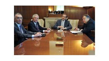 El banquero Vassilios Rápanos reunido junto con los líderes de la coalición de Gobierno griego.