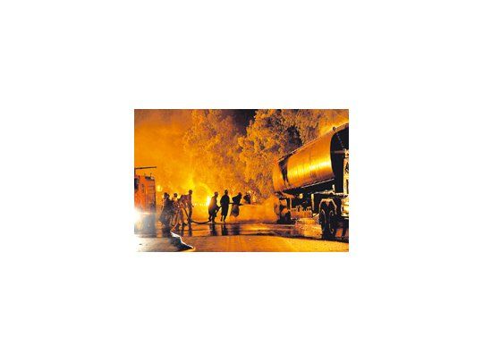 Bomberos paquistaníes tratan de extinguir las llamas que emanan de un camión cisterna de la OTAN, luego de un nuevo ataque de los talibanes. Los rebeldes golpean la logística de los aliados luego de una fallida incursión aérea.