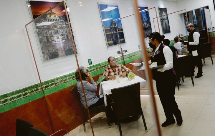 NUEVA NORMALIDAD. Un restaurante de la Ciudad de México volvió a abrir sus puertas luego de tres meses de confinamiento. Los locales deben incluir una placa que separe las mesas de comensales entre sí.