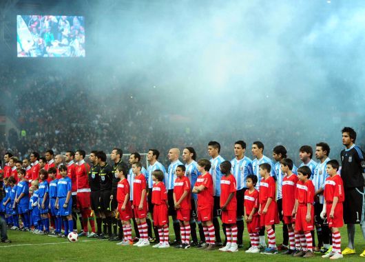 Ambas selecciones cantando sus himnos
