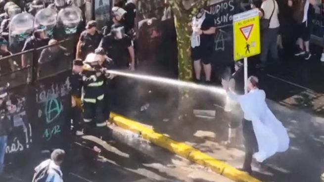 Un miembro de las fuerzas de seguridad disuadiendo a los manifestantes mediante el uso de agua.
