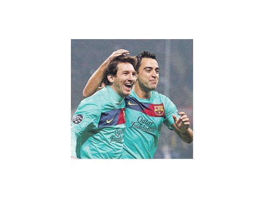 Xavi felicita a Lionel Messi por el pase que le puso en el tercer gol. El rosarino fue otra vez el jugador desequilibrante del Barcelona.