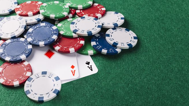 dos-ases-jugando-cartas-fichas-sobre-fondo-verdejpg