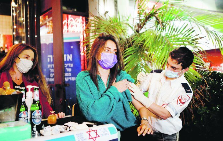 MOTIVACIÓN. Una mujer es vacunada en Tel Aviv. La municipalidad de la ciudad ofreció a sus ciudadanos una bebida a cambio de acceder a inocularse.&nbsp;