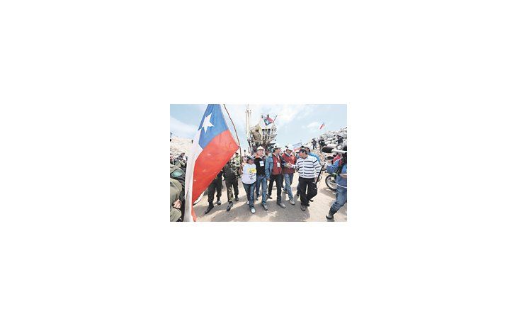 Familiares de los mineros atrapados en Copiapó y rescatistas acompañan el retiro de la máquina perforadora T130, la que logró abrir el túnel que permitirá el rescate. La operación será riesgosa, pero la expectativa es fuerte.
