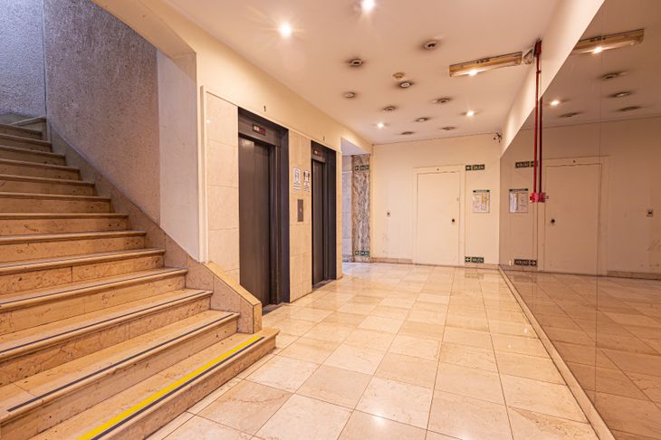 Hall de acceso del edificio, con pisos de mármol original, escalinata y núcleo de ascensores que conecta con las plantas superiores y el histórico chalecito ubicado en la terraza Hall de acceso del edificio, con pisos de mármol original, escalinata y núcleo de ascensores que conecta con las plantas superiores y el histórico chalecito ubicado en la terraza