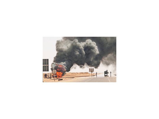 Una camioneta en la que se trasladaban dos efectivos gadafistas arde en una ruta cercana a Sirte. En esa ciudad, bastión del exdictador, se librará la batalla final de la guerra civil libia.