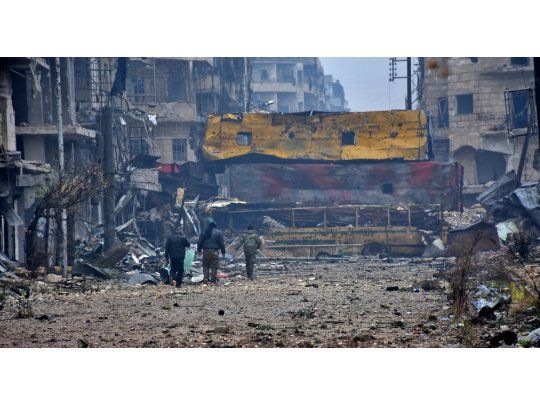 Fuerzas progubernamentales caminan por Alepo tras la rendición de los opositores.
