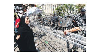 Una mujer musulmana canta consignas frente a policías militares durante una protesta contra la candidatura presidencial del mubarakista Ahmed Shafiq, que también ayer quedó autorizada por el Tribunal Constitucional.