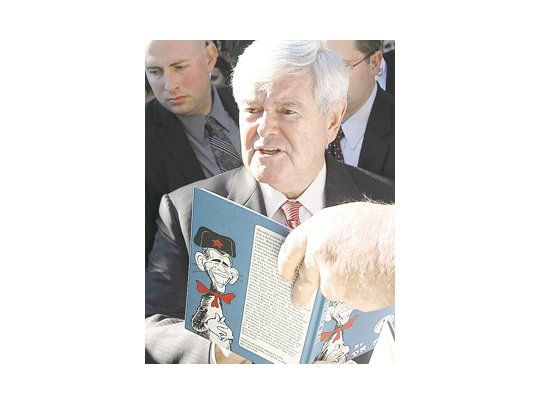 Newt Gingrich ayer, al autografiar el libro El Nuevo Demócrata, una parodia de la administración de Barack Obama (caricatura incluida).