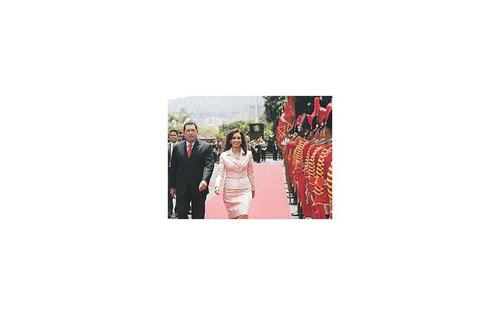 ámbito.com | Cristina de Kirchner camina junto a Hugo Chávez, con un looken el que predomina el rosado, color que connota paz, perotambién romanticismo y dulzura.