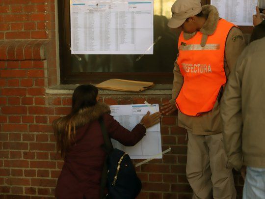 El prefecto ayudando a un votante a encontrarse en el padrón.