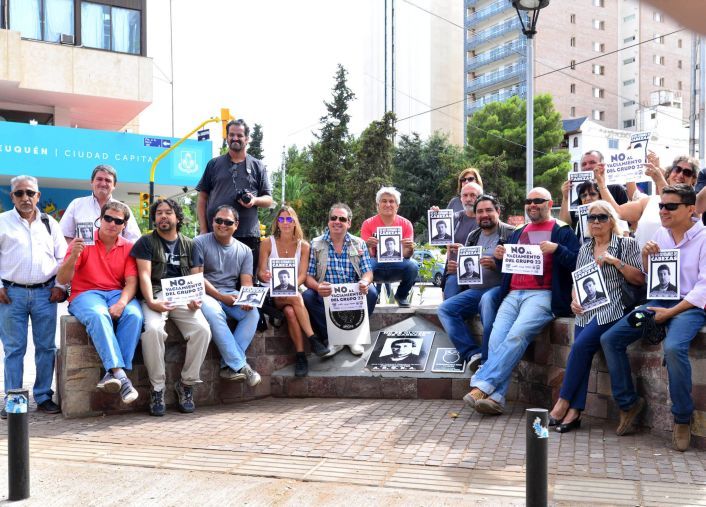 Reporteros gráficos nequinos posan junto a carteles con la cara de Cabezas.