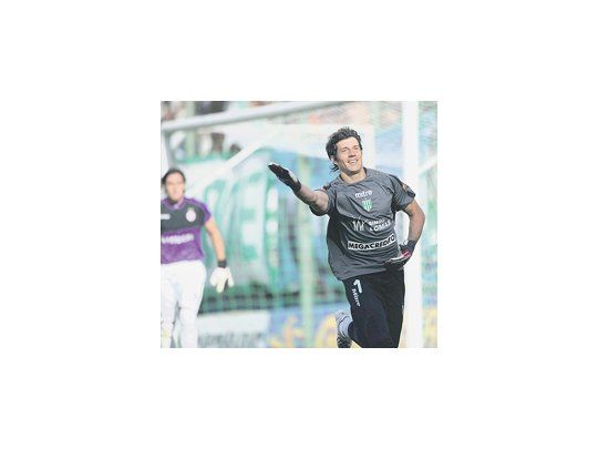 Enrique Bologna festeja el primer gol de su carrera cargando a su colega Caranta. Banfield ganó el clásico y fue un gran espaldarazo para su técnico Méndez.