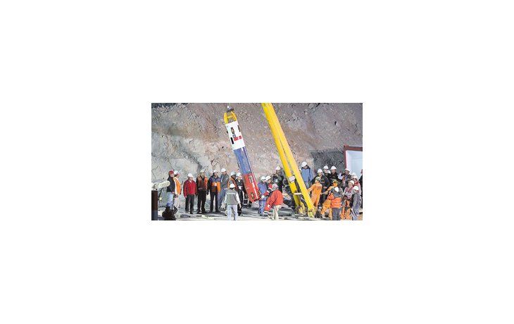 La televisión mundial siguió paso a paso los preparativos de la cápsula antes del inicio de la operación de rescate de los mineros (izquierda). Los retratos de los trabajadores anticipaban en el campamento el esperado reencuentro con sus seres queridos (derecha).