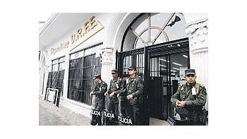 Efectivos de seguridad protegen la puerta de una financiera involucrada en un fraude de tipo piramidal en la ciudad colombiana de Popayán. Miles de personas estafadas protagonizan desde el miércoles violentos disturbios en varias ciudades.