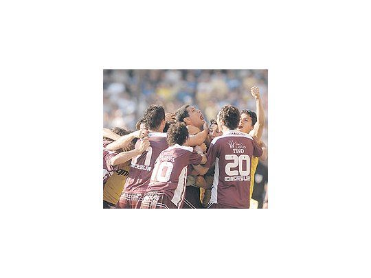 José Sandfesteja su gola boca llenamientras suscompañerosse pelean porabrazarlo.Lanús es unjusto campeóndel torneoApertura,donde fue elmejor.