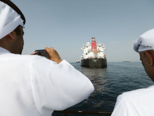 registro. Un funcionario portuario de Emiratos Árabes Unidos le saca una foto a uno de los barcos dañados por los denunciados actos de sabotaje, el Andrea Victory.