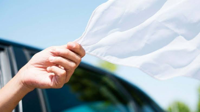 Sacar tela blanca por la ventana del coche.