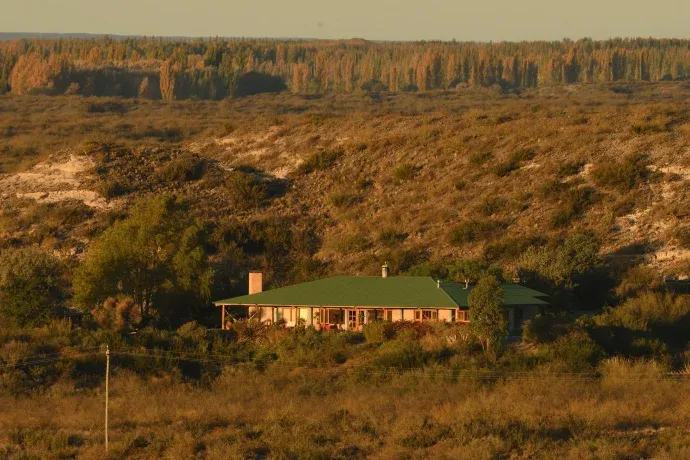 La casa, al pie de la barda.