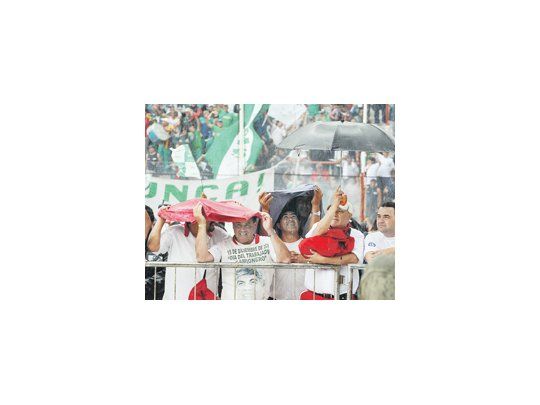 La lluvia casi arruinó el acto de Hugo Moyano ayer en la cancha de Huracán. El camionero, tapado de agua, prometió seguir hasta el final, comprometiendo a los presentes, pero algunos optaron por salir para cuidarse del aguacero.