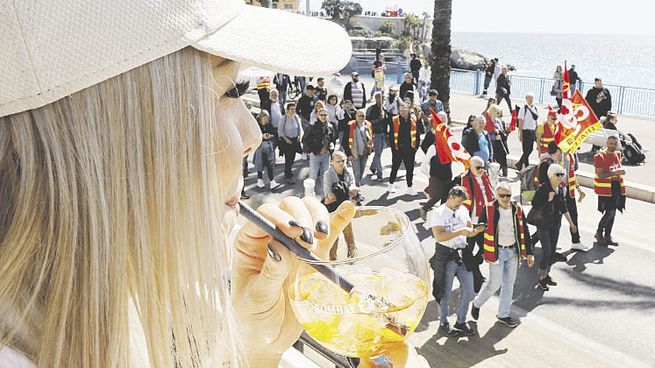 COTIDIANEIDAD. Una mujer bebe un trago y observa los enfrentamientos en Niza, una de las ciudades más convulsionadas por las protestas.