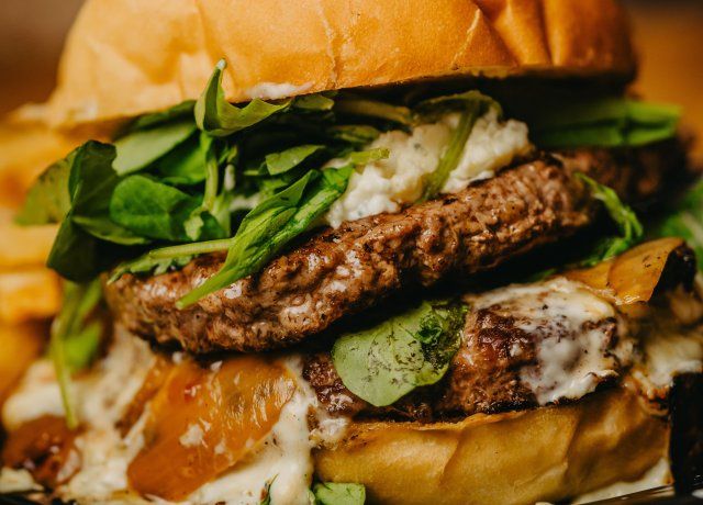 La hamburguesa Bulebar viene con queso azul, hongos, cebolla asada y rúcula. La hamburguesa Bulebar viene con queso azul, hongos, cebolla asada y rúcula.