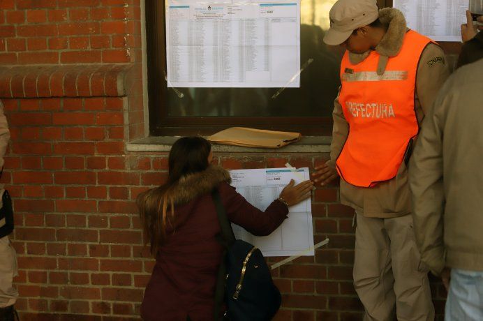 El prefecto ayudando a un votante a encontrarse en el padrón.