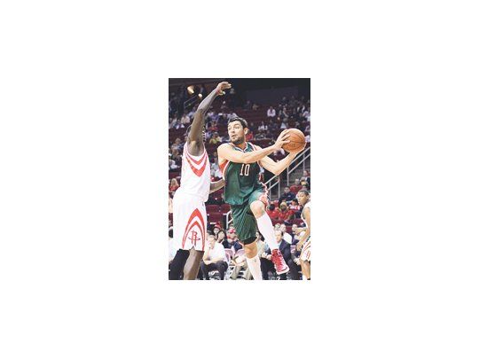 Carlos Delfino intenta el pase ante la marca de Samuel Dalembert. El «Lancha» le ganó el duelo entre argentinos a Luis Scola.