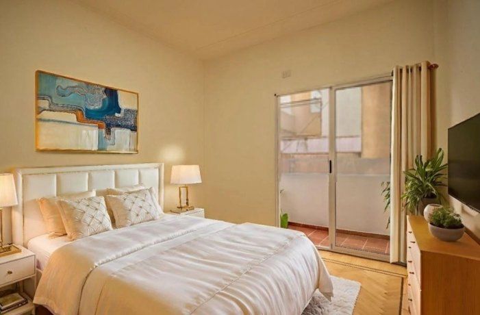 Dormitorio de un departamento de dos ambientes con salida al balcón