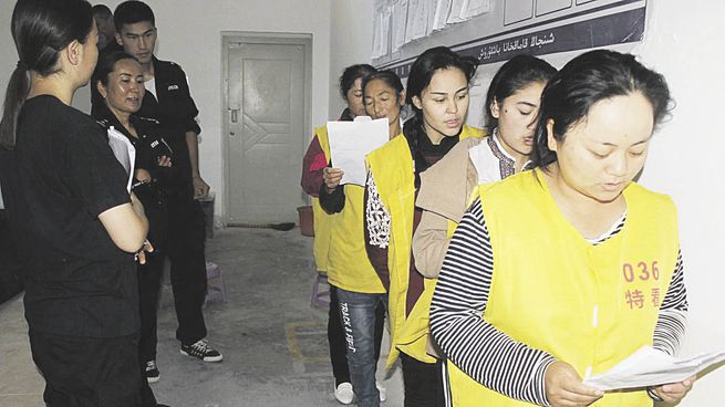 ADOCTRINAMIENTO. La foto, divulgada por un consorcio internacional de medios, muestra a un grupo de mujeres uigures con material para su reeducación política en un centro de detención.