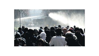 ámbito.com | Estudiantes mantienen ayer prudente distancia del chorro de agua que lanza un camión de los carabineros.