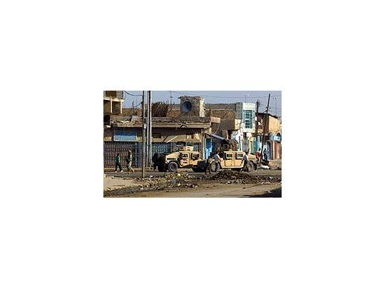 Soldados iraquíes patrullan la escena de las explosiones en el centro de Bagdad.