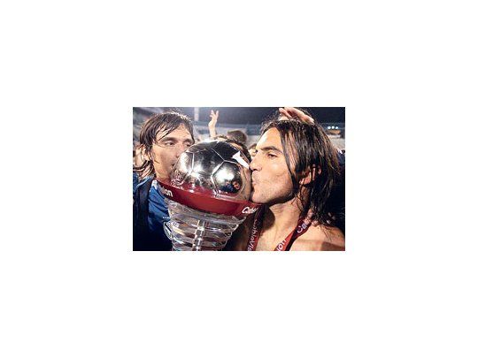 Fabián Cubero besa la Copa, junto al arquero suplente Barovero
