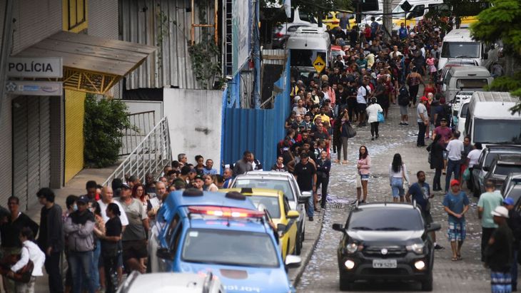 Personas fuera de un local de votación en Río de Janeiro, Brasil.