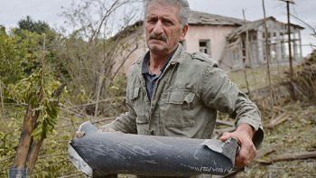 IMPACTO. Un hombre sostiene una pieza de munición tras lo que los lugareños afirman fue un bombardeo de las fuerzas azeríes, en la ciudad de Martuni, en la región separatista de Nagorno-Karabaj.