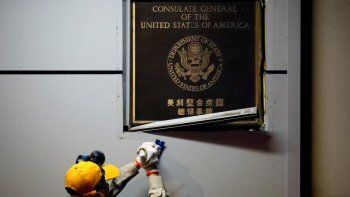 Un funcionario chino retira la placa de identificaci&oacute;n del consulado de Estados Unidos en Chengdu.