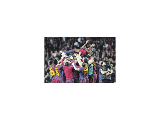 Los jugadores de Barcelona revolean a Eric Abidal, que pudo volver a jugar después de que le extirparon un tumor en el hígado hace dos meses. Fue el momento más emotivo del partido.