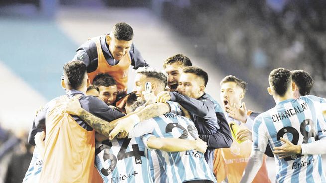 festejo. Todo Racing abraza a Carlos Alcaraz, que marcó dos goles y fue la figura excluyente del partido.