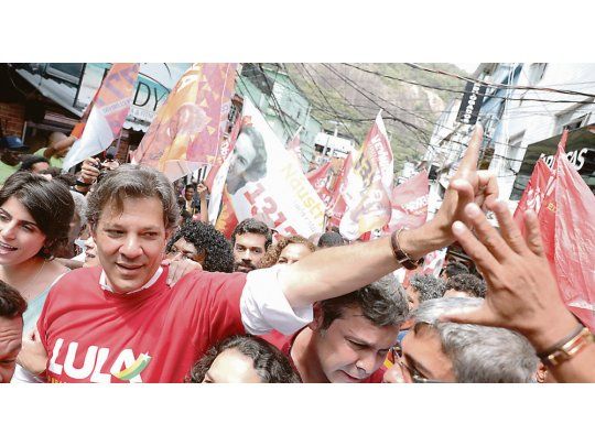 IDENTIFICACIÓN. Con una remera roja y la leyenda “Lula”, Fernando Haddad recorrió la favela Rocinha en Río de Janeiro. El presidenciable del PT busca concitar toda la intención de voto del encarcelado expresidente.