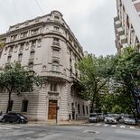 La esquina de Juncal y Uruguay exhibe la imponente volumetría curva diseñada por Christophersen, con ornamentación clásica, balcones de piedra y una fachada protegida por su valor patrimonial