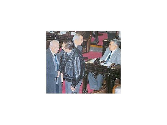 Oscar Lamberto y Saúl Ubaldini le dan la espalda la noche del miércoles al duhaldista bonaerense Domingo Vitale, quien intentaba seguir negociando el desagravio a Eduardo Duhalde en Diputados que finalmente no fue. Interesado, lo escucha Alberto Coto.