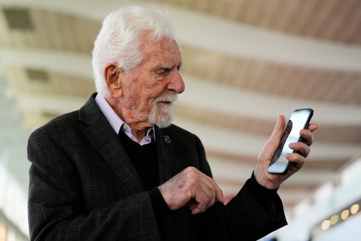 Martin Cooper, pionero de la telefonía móvil, junto a un teléfono del siglo XXI.