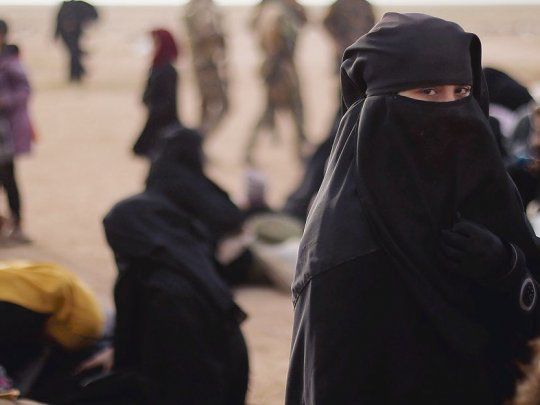 GUERRAS INSOSTENIBLES. Una joven observa a la cámara en Bahhouz, Siria, donde fuerzas kurdo-árabes disputan la última batalla contra el Estado Islámico (EI). Donald Trump afirma que la batalla contra el yihadismo está a un solo paso, aunque es desmentido por sus propios asesores.