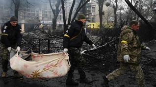 Servicios de emergencias ucranianos trasladan un cuerpo.