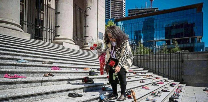 Delhia Nahanee, del pueblo Squamish, coloca rosas entre los 215 pares de zapatos infantiles.