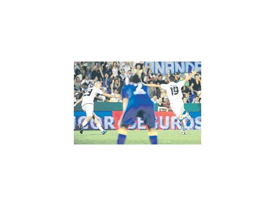 Fernando Ortiz por un lado y Santiago Silva por el otro festejan el único gol del partido, mientras, fuera de foco Matías Caruzzo se lamenta. Vélez ganó 1 a 0.