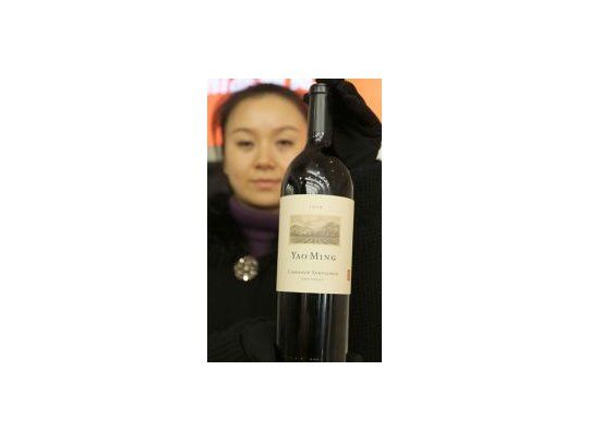 Botella. La mujer muestra el cabernet sauvignon que será subastado el domingo con una base de 7000 euros.