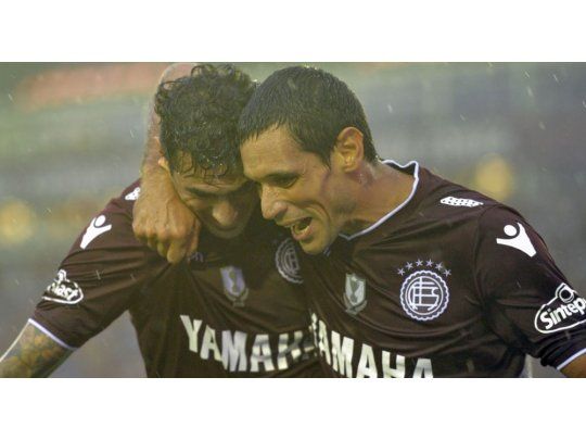Román Martínez abraza a José Sand, el goleador que no falló y fue figura en el clásico entre Lanús y Banfield.